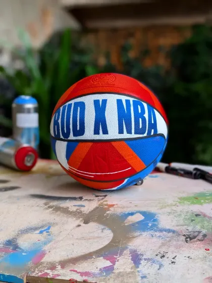 The custom basketball on my paint-splattered work table, with spray cans in the background. This is where the magic happens.
