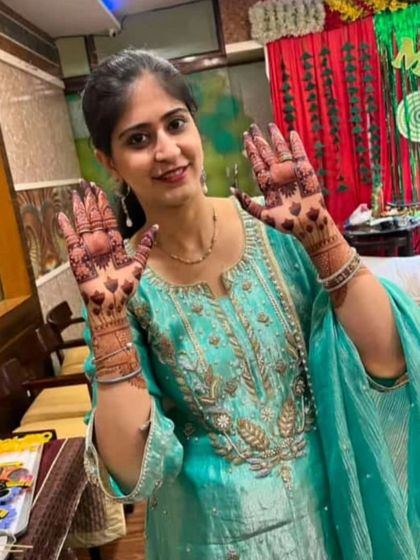 A happy client proudly showing her fresh mehendi. The design is simple yet elegant, perfect for a festival or a family get-together.