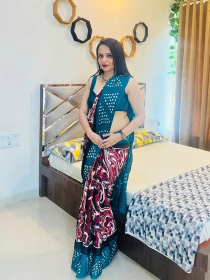 This is a lightweight printed saree perfect for parties or festive gatherings. The teal base is accented with a bold red and white marble-effect print on the pallu, creating a modern and artistic statement.