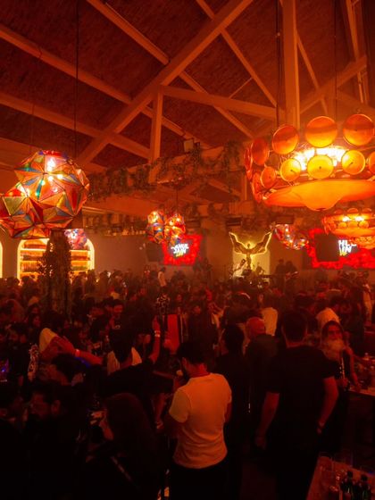 Another view of the packed club, showing the unique lighting fixtures and the sheer number of people on the dance floor.
