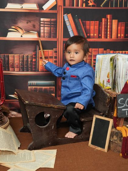 This little student is ready to teach the class. The pose with the pointer stick adds a touch of playful authority to this adorable themed kids' portrait.