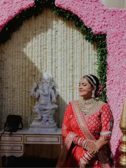 Seeking blessings on her special day. This candid shot shows the bride in a serene moment, her traditional makeup looking flawless even in the bright sunlight.