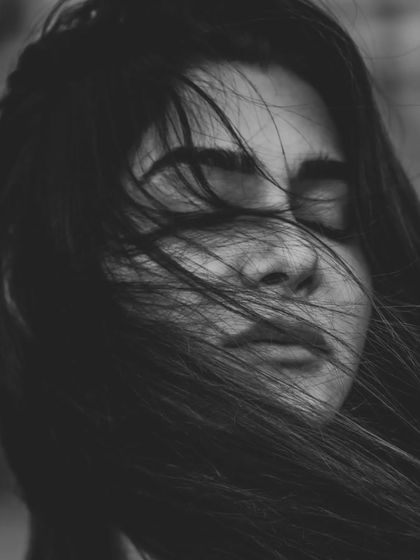 A close-up version of the windswept portrait, this black and white image is incredibly intimate. The focus is on the texture of the hair and the peaceful expression on the model's face, creating a powerful emotional moment.