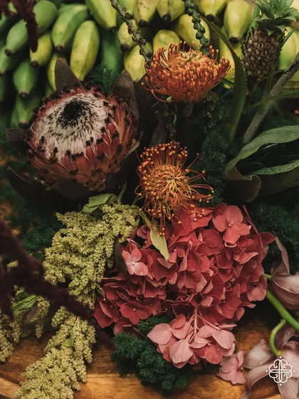 A detail of the floral and fruit arrangements from the 'Orchard of Life' event, featuring proteas and bananas.
