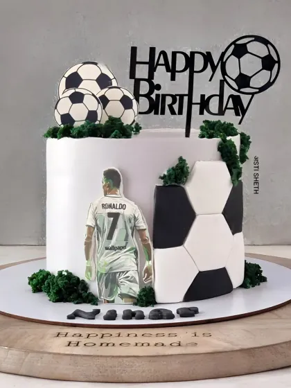 A sleek and modern football cake for a Ronaldo fan. The design features a 3D football pattern and a silhouette of the star player.