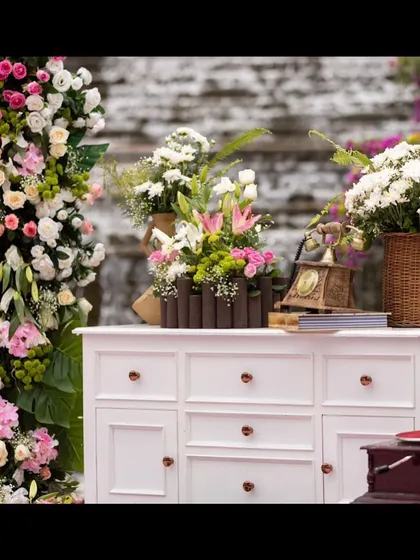 An enchanting blend of vintage and modern decor for a welcome brunch. We used a classic white dresser as a base for lush floral arrangements, creating a beautiful and unique focal point.