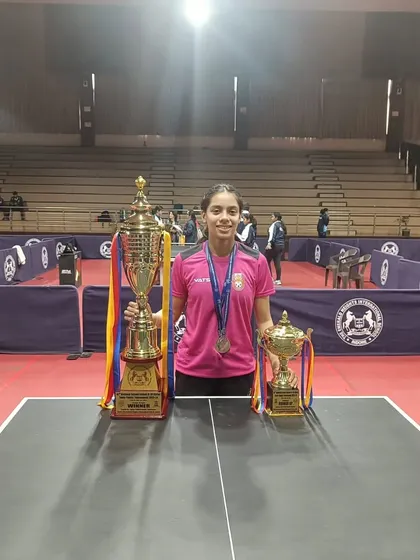 A full-length shot of Ananya Chande on the court with her trophies from the SGFI games. She stands as a role model for aspiring young players in our academy.