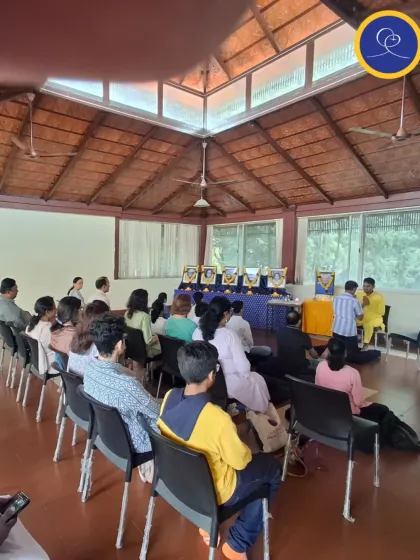 A wide view of the purification ceremony during a Sunday Satsang. Devotees stand in a line, waiting to come forward and make their offering of self to the Divine, supported by the prayers of the community.