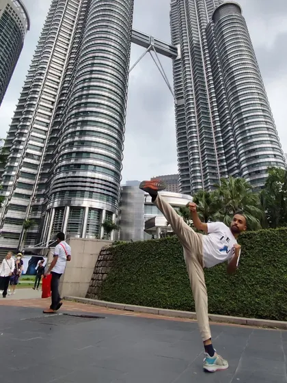 A high kick in front of the Petronas Twin Towers in Kuala Lumpur. Martial arts is an adventure, and I take my practice with me wherever I go.