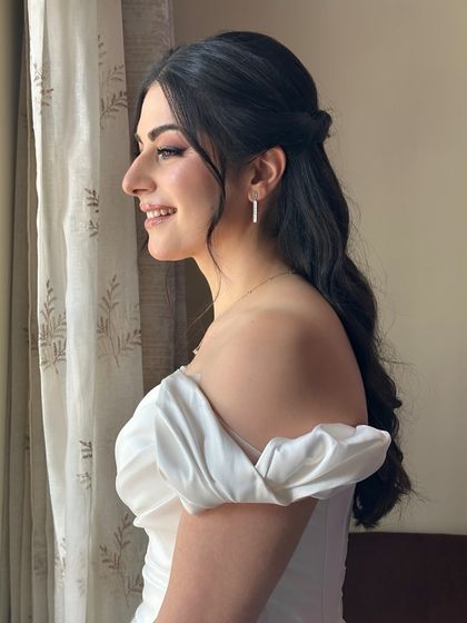 A side profile of my German bride Ozlem's white wedding look. Her hair is styled in soft, dreamy waves, half-up to keep it off her face, perfect for her elegant off-shoulder dress.