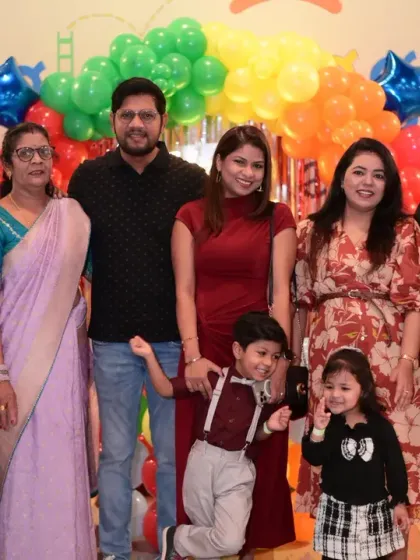 A family posing in front of a colorful balloon arch. A perfect photo to remember the day.