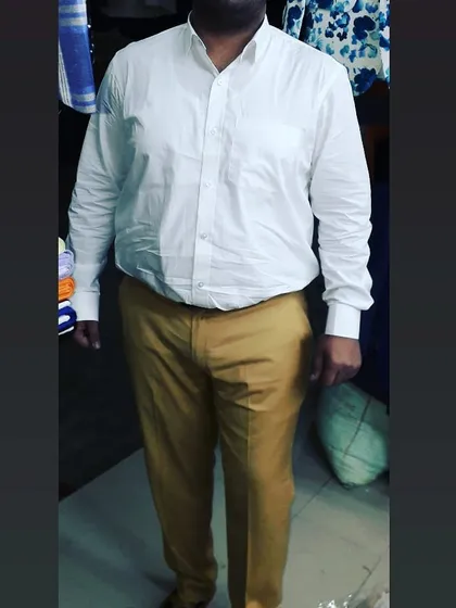A classic white formal shirt paired with khaki trousers, both tailored for this client. I ensure the shirt has enough room in the shoulders and the trousers have the perfect break at the shoe.