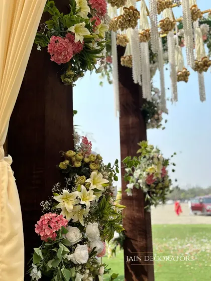 A close-up of the florals on an entrance arch. The mix of lilies, hydrangeas, and roses in soft pastel shades creates a welcoming and beautiful first impression.