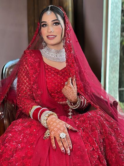 Seated like a queen, Anjali is ready for her big day. The way the light catches the sequins on her lehenga and the sparkle in her makeup is just magical.