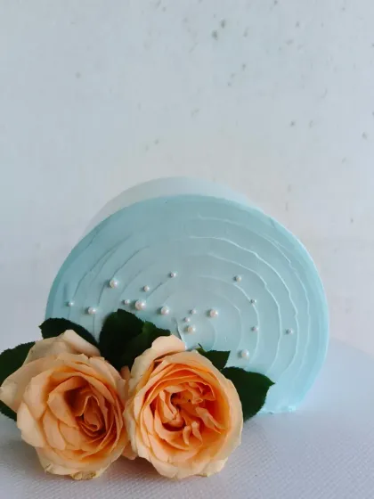 A unique "top forward" or "illusion" cake, decorated with fresh peach roses. This modern and artistic style is sure to be a conversation starter.