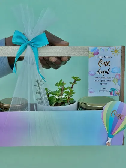This pastel rainbow-themed hamper for a first birthday is one of my favorite creations. It includes a beautiful succulent plant and two jars of treats, all brought together with custom tags and a delicate net wrapping, showing how we tailor every detail to your theme.
