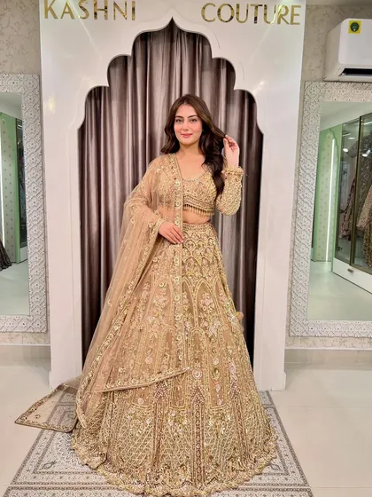 A full-length shot of a model in a glittery golden lehenga. This is the ultimate glam outfit for a sangeet or reception.