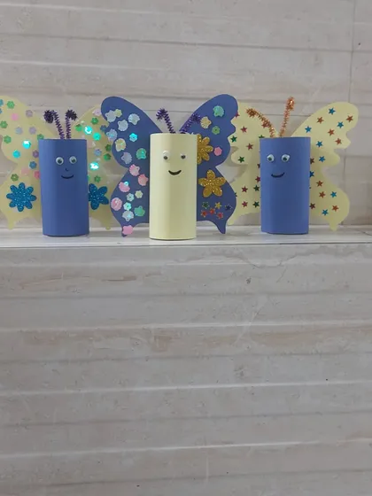 A family of butterfly crafts made from toilet paper rolls and decorated with colorful paper and sequins. This is a great example of our sustainable and imaginative DIY projects.