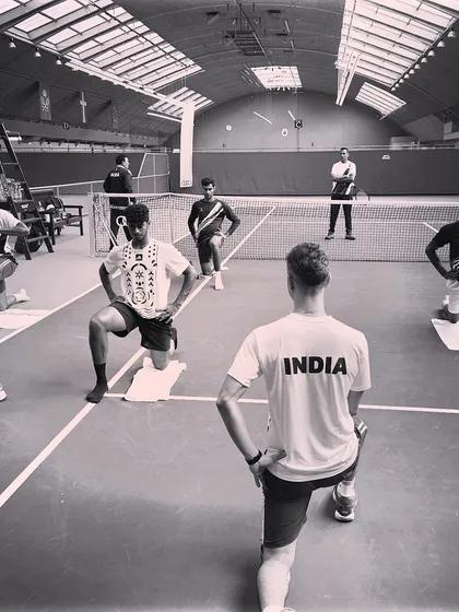 Leading a group warm-up session on an indoor court. Synchronized movements like these lunges help build team cohesion while properly preparing the athletes' muscles for the intense session ahead.