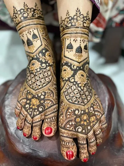 I love adding personal touches to your bridal mehendi. For this design, I incorporated delicate jhumka (earring) motifs into the foot henna, blending them with classic floral and net patterns for a unique and meaningful look.