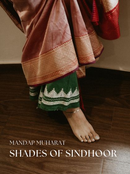 A detail shot showing the layered effect of wearing a family heirloom. Here, the bride wears her grandmother's green chaniya underneath a beautiful red saree for her Mandap Muharat, a subtle yet powerful nod to her roots.