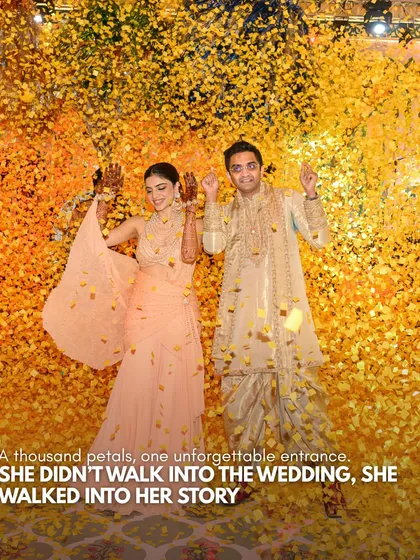 A thousand petals, one unforgettable entrance. The bride and groom are showered in golden confetti as they make their entrance, a moment of pure joy and celebration that marks the beginning of their story.