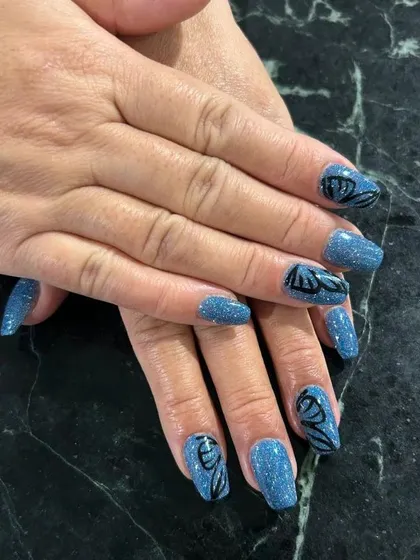 A magical look featuring a sparkling blue glitter base with hand-painted black butterfly wings.