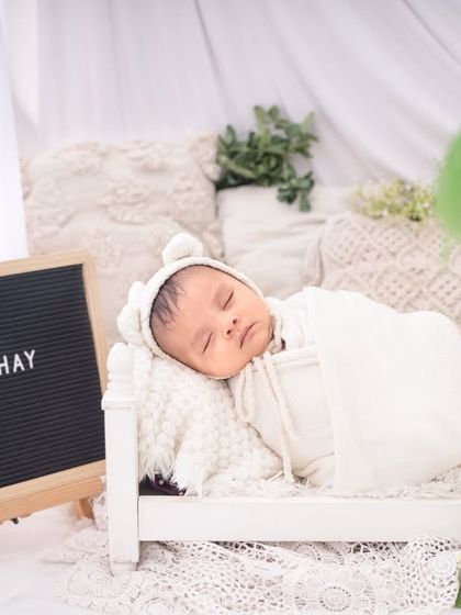 Personalizing your session with a name board is a wonderful touch. This baby sleeps soundly in a classic, all-white setup.