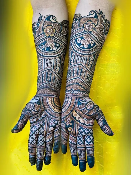 A stunning bridal henna design featuring majestic peacocks and intricate architectural patterns. The use of negative space and bold fills makes the detailed work pop, creating a truly memorable look for the bride.