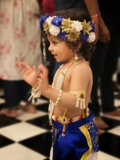 A joyful, candid moment of the little Kanhaji clapping and smiling. This photo captures the pure, unscripted happiness of childhood and celebration.