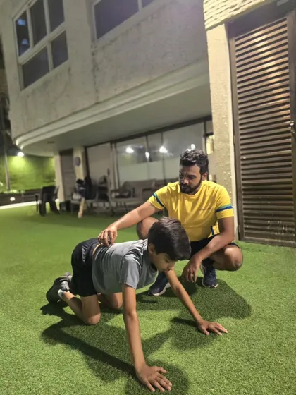 Proper form is everything. Here, our coach guides a young athlete through a bear crawl, an excellent functional exercise for building core strength and shoulder stability, crucial for any cricketer.