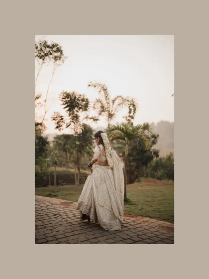 A lovely shot of the bride from the back, walking along a path in a beautiful garden setting.