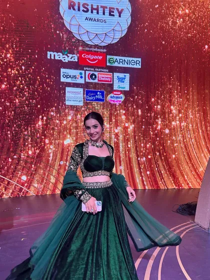 Posing on the awards stage. Her confidence shines through, and the makeup looks impeccable.