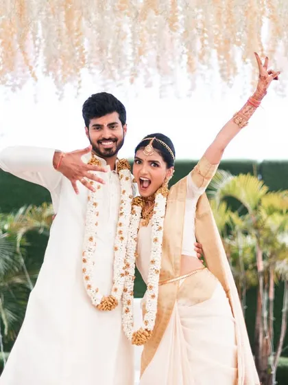 A fun, high-energy pose from a South Indian wedding. This shows the couple's playful side and their excitement on the big day.