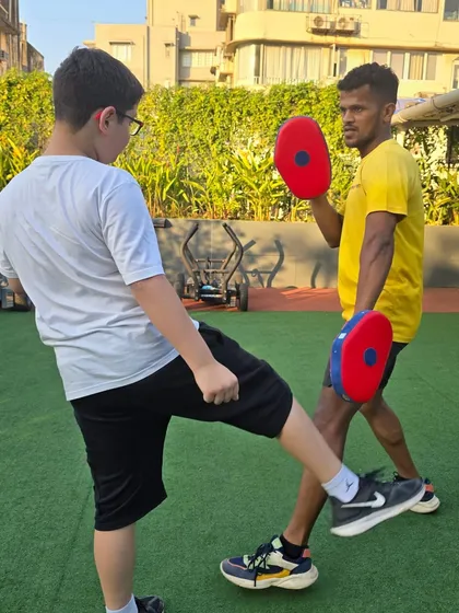 Kickboxing drills are fantastic for developing balance and lower-body power. Here, a young athlete executes a controlled kick, a key movement in our MMA fitness program.