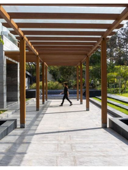 A person walking along the covered stone pathway. This image shows the human scale of the architecture and how the design encourages movement and exploration of the property.