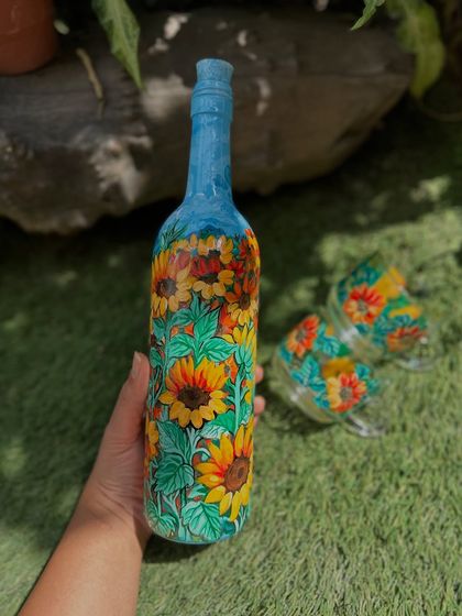 A full view of our hand-painted sunflower bottle. The vibrant yellow flowers cover the entire surface, creating a stunning piece of decor that brings a little sunshine indoors.
