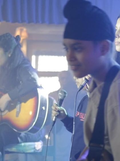 A snapshot of a full student band on stage, featuring vocalists, guitarists, and keyboardists. This is the collaborative energy our ensemble program is all about.