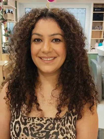 A stunning transformation for curly hair. The new colour enhances her natural curls, giving them definition and a healthy shine after an Olaplex treatment.
