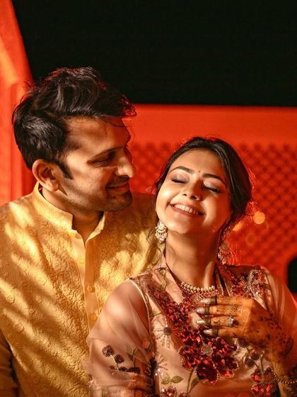 A candid moment of laughter and love, with the couple bathed in a warm, golden light.