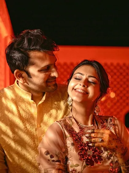 A candid moment of laughter and love, with the couple bathed in a warm, golden light.