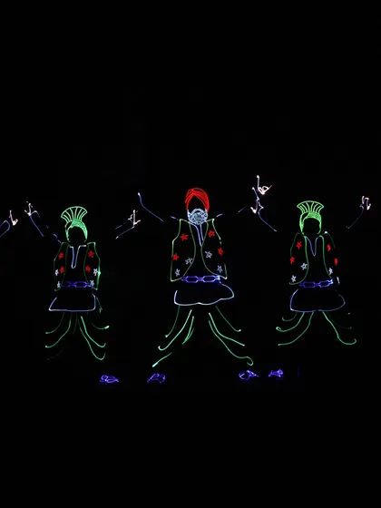 Five of our dancers in full LED Bhangra attire, captured mid-performance. The green and red lights on the kurtas and turbans create a festive and energetic feel.