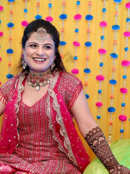 A radiant bride laughing during her mehndi ceremony.