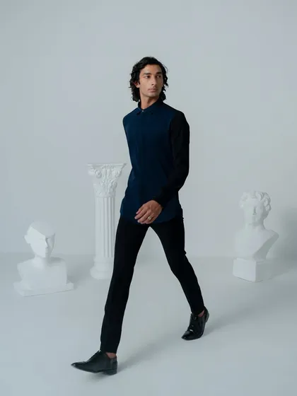 The 'Midnight Aurora' ensemble pairs a navy blue structured top with black tailored trousers. It's a minimalist look that commands attention through its sharp lines and color blocking.