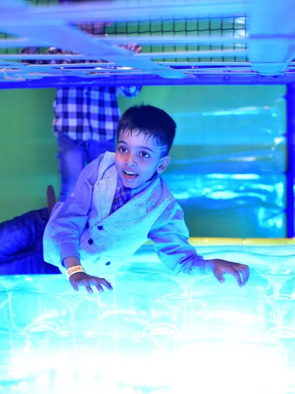 A boy having a great time on the illuminated floor panel, a unique sensory feature in our play area.