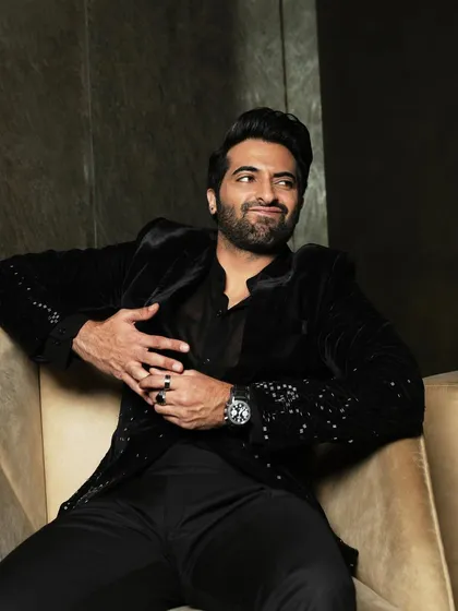 A playful and engaging seated portrait, showcasing the actor's personality.