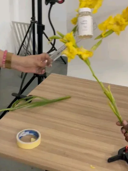 A team effort to create a floating effect, with two people holding the product and flowers in place for a composite shot.