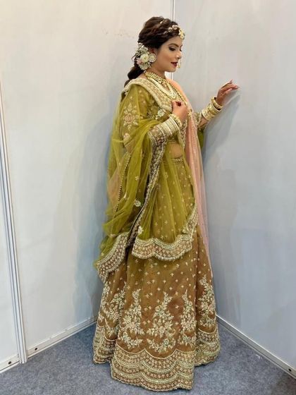 The full view of this stunning mehndi green and brown lehenga shows its graceful fall and intricate detailing. It’s a wonderful option for brides looking for something traditional yet unique for their wedding day.