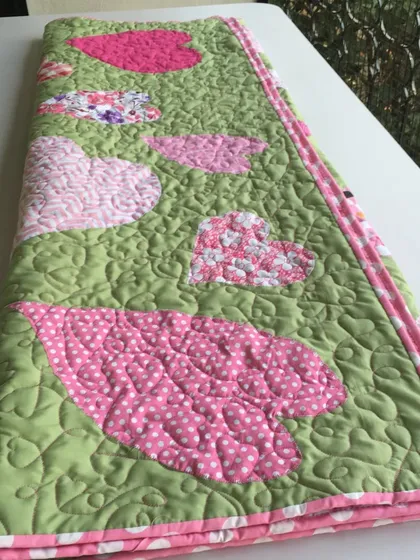 A different heart-themed quilt, with appliquéd hearts on a green background.