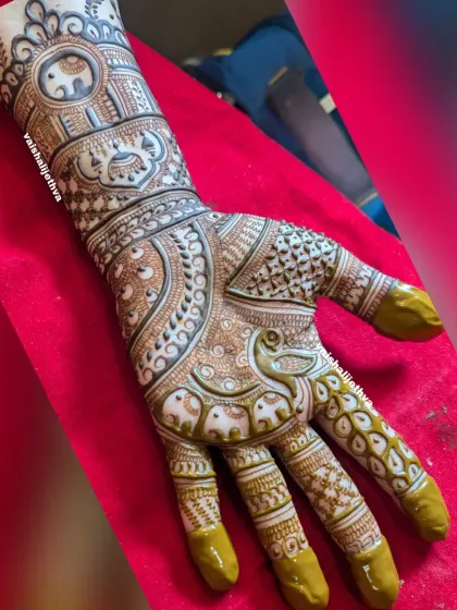 An intricate bridal design featuring rows of elephants on the wrist and fingers, with a peacock on the palm.
